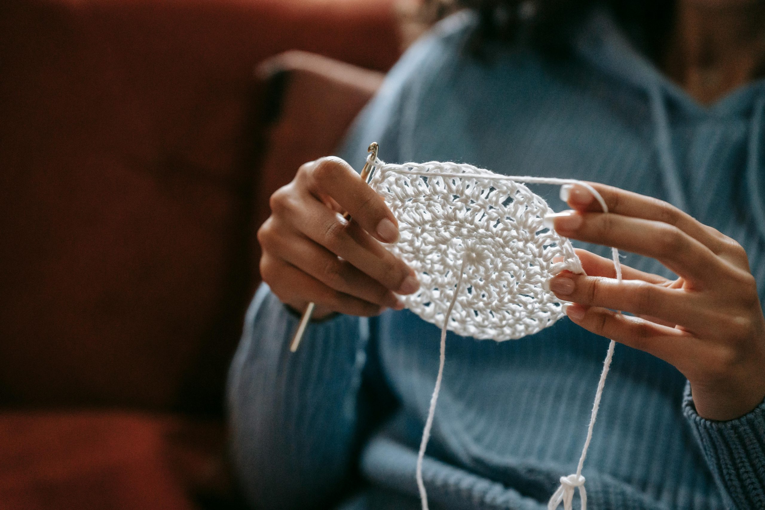 woman knitting a white coaster